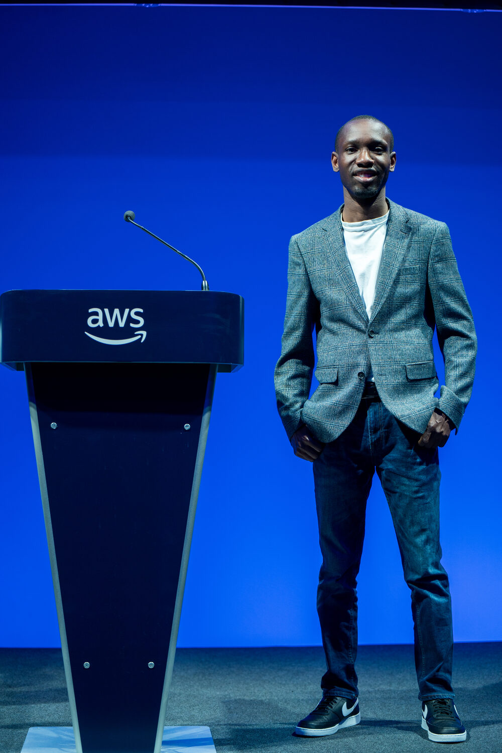Olushola Oladipupo on stage beside the AWS podium at AWS Summit London
