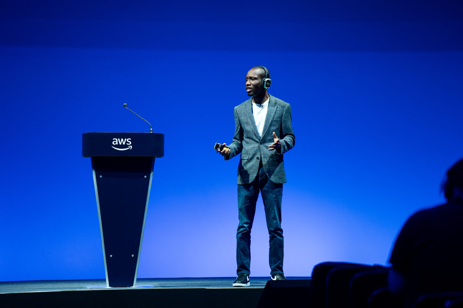 Olushola Oladipupo mid-talk on stage at AWS Summit London